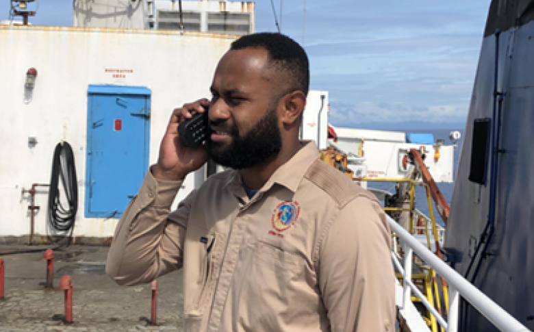A communications officer from the Fiji National Disaster Management Office (NDMO) contacts the Ministry of Meteorology, Energy, Information, Disaster Management, Environment, Climate Change and Communications (MEIDECC) in Tonga from a Fijian emergency response supply vessel via WFP satellite phone. Photo: Fiji NDMO